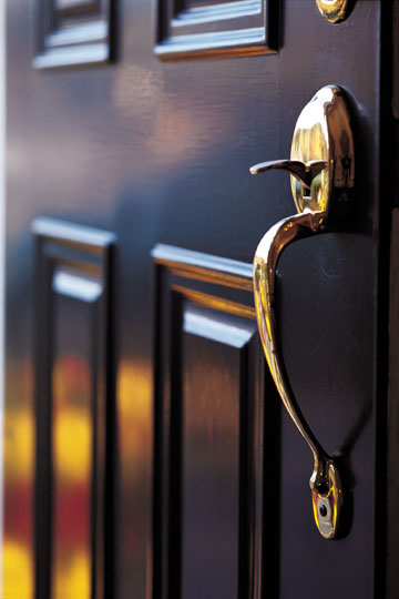 Inviting open wooden house door with warm golden glow.